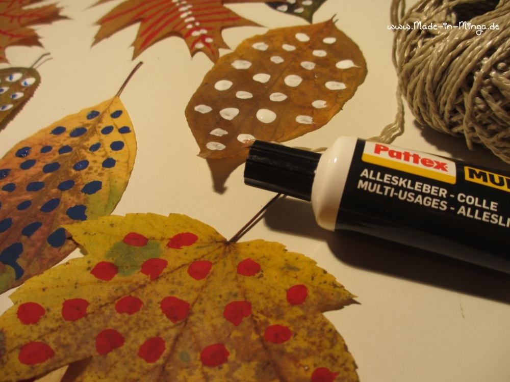 Getrocknete Blätter an einer Schnur festkleben - Herbstdeko basteln